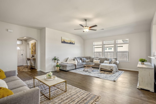 living room featuring arched walkways, visible vents, dark wood finished floors, and baseboards