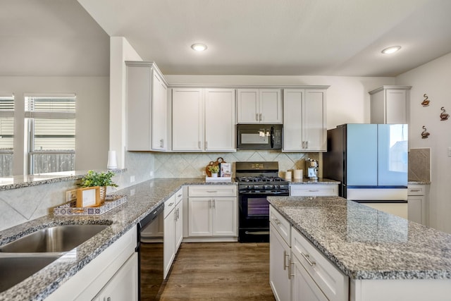 kitchen featuring decorative backsplash, black appliances, dark wood finished floors, and light stone countertops