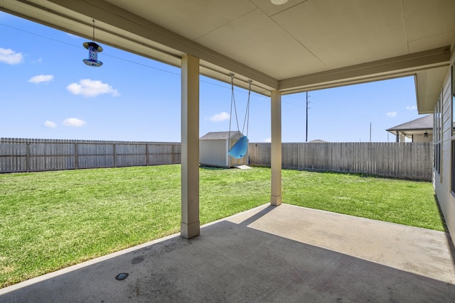 view of yard with a storage unit, a patio, an outdoor structure, and a fenced backyard