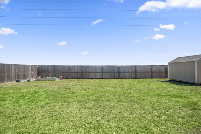 view of yard with an outbuilding, a fenced backyard, and a shed