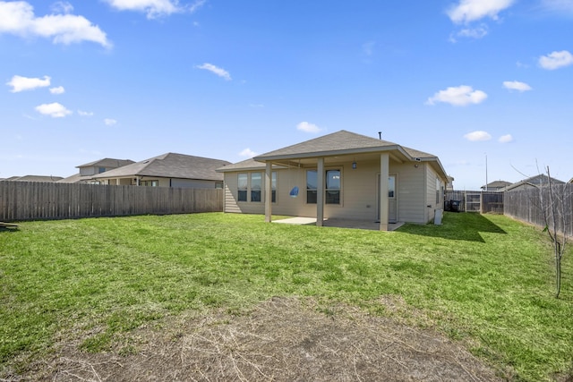 back of house featuring a patio, a yard, and a fenced backyard