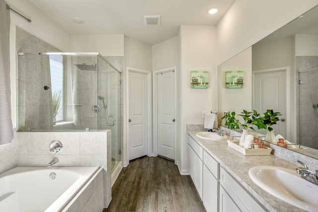 bathroom with a bath, visible vents, a stall shower, and a sink