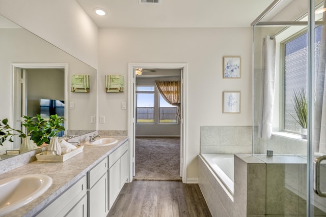 full bath featuring double vanity, a bath, visible vents, and a sink