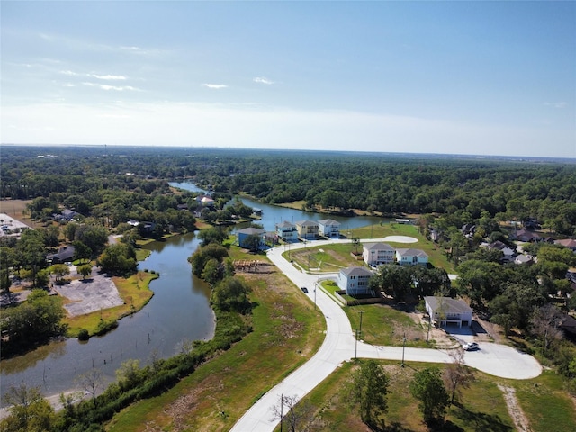 birds eye view of property featuring a forest view and a water view