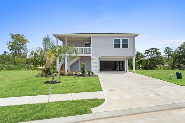 beach home with concrete driveway, a porch, stairway, and a front yard