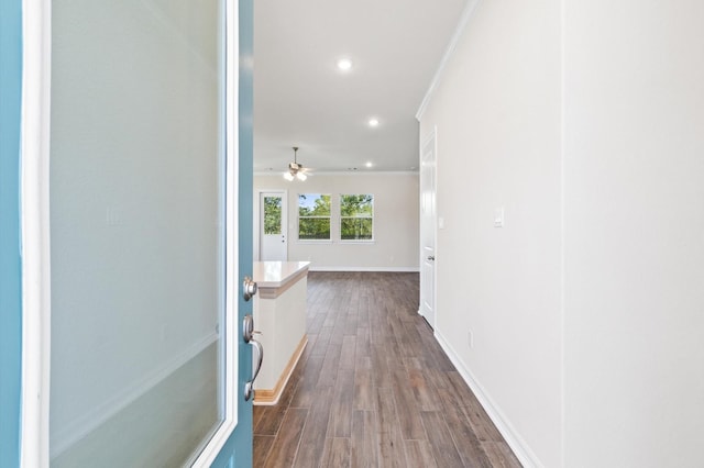 hall featuring baseboards, ornamental molding, dark wood-type flooring, and recessed lighting