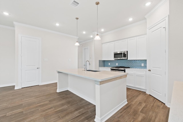 kitchen featuring wood finished floors, a sink, visible vents, appliances with stainless steel finishes, and tasteful backsplash