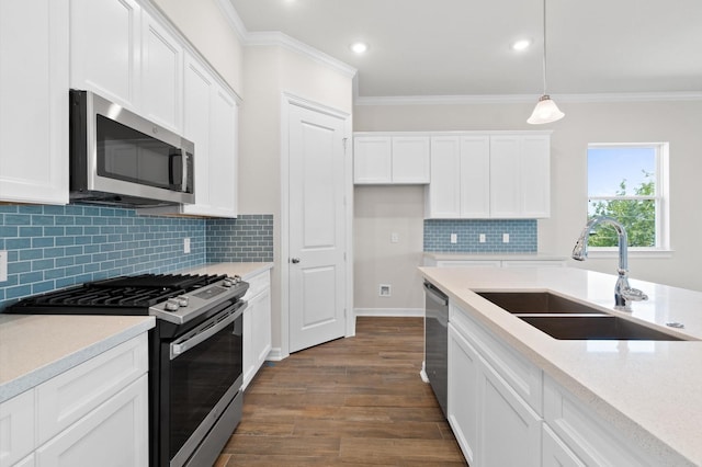 kitchen with stainless steel appliances, dark wood-type flooring, a sink, white cabinetry, and crown molding