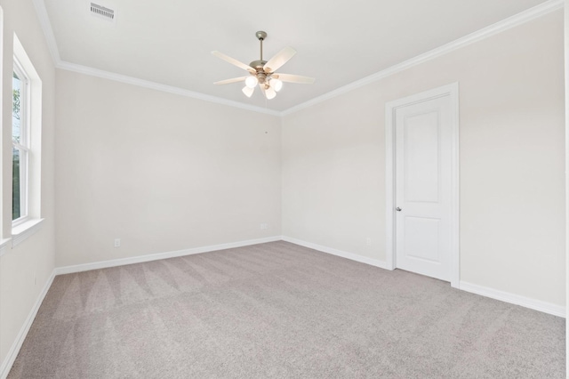 spare room featuring baseboards, carpet, visible vents, and crown molding