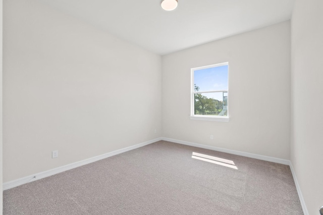 spare room featuring carpet floors and baseboards