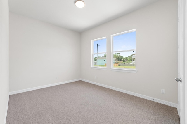 spare room featuring carpet and baseboards