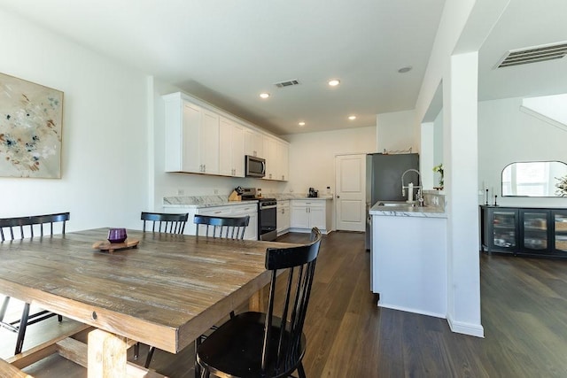 dining room featuring dark wood-type flooring, visible vents, and recessed lighting