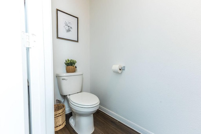 bathroom featuring toilet, baseboards, and wood finished floors