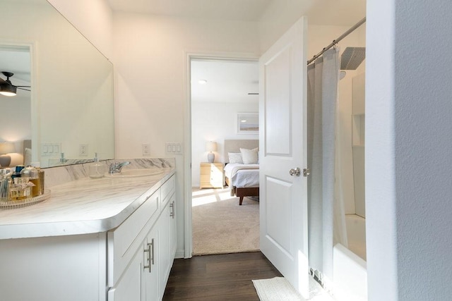 bathroom with ensuite bath, ceiling fan, wood finished floors, and vanity