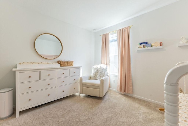 living area featuring baseboards and light colored carpet