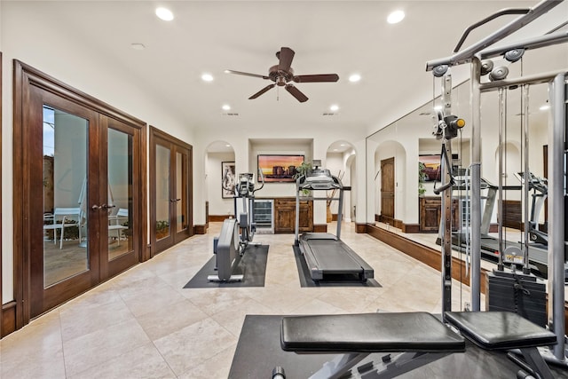 workout area with a ceiling fan, recessed lighting, arched walkways, light tile patterned floors, and baseboards