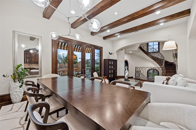 dining space featuring stairway, beam ceiling, recessed lighting, arched walkways, and french doors