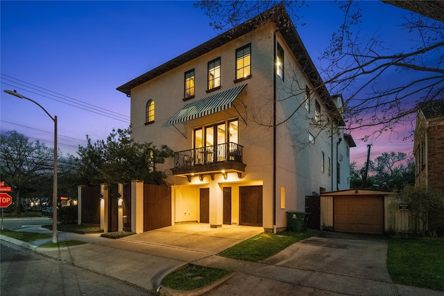 mediterranean / spanish house with concrete driveway, a balcony, a garage, and stucco siding