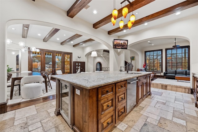 kitchen featuring stone tile floors, open floor plan, recessed lighting, and a sink