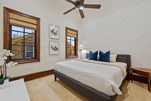 bedroom with multiple windows, an accent wall, and wallpapered walls