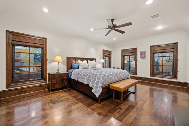 bedroom with dark wood-style floors, visible vents, multiple windows, and recessed lighting