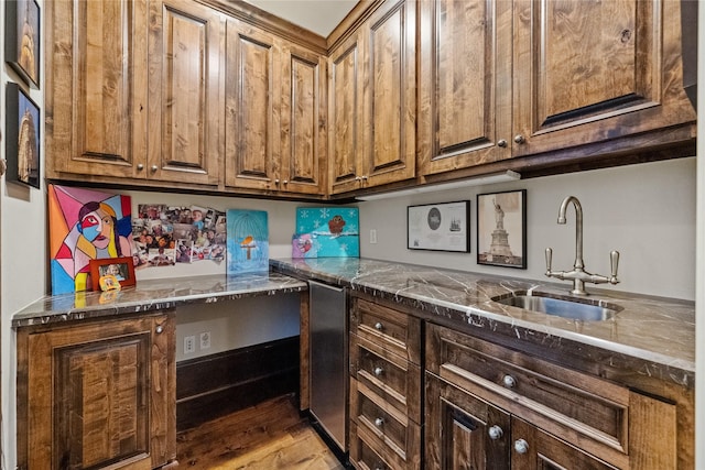 kitchen featuring brown cabinets, light wood-style floors, and a sink