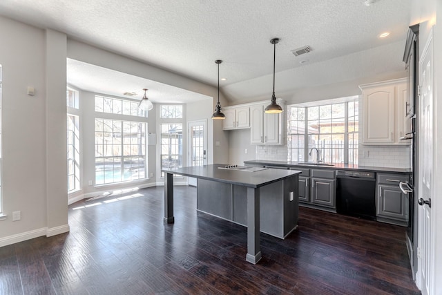 kitchen with dark wood-type flooring, dark countertops, black appliances, and white cabinetry