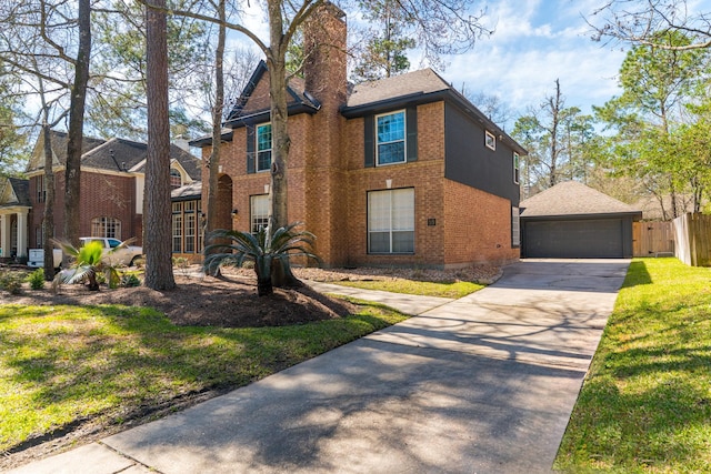 traditional-style home featuring brick siding, an outbuilding, a garage, and fence