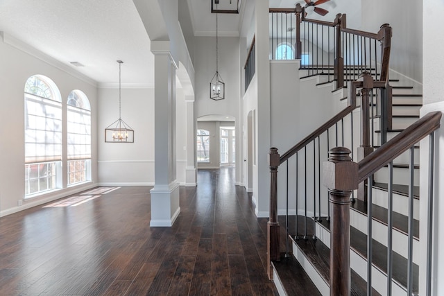 foyer entrance featuring ornamental molding, wood finished floors, and a healthy amount of sunlight