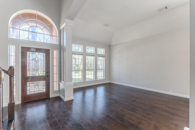 entryway with dark wood-type flooring, visible vents, and ornate columns