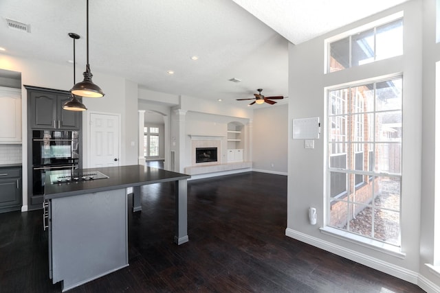 kitchen featuring visible vents, black appliances, gray cabinets, a ceiling fan, and dark countertops