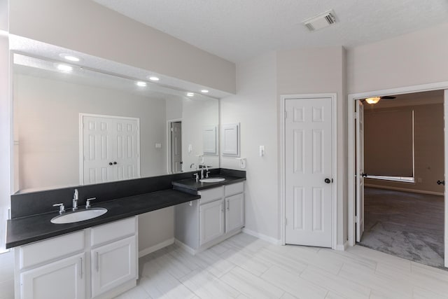 full bathroom featuring a sink, visible vents, baseboards, and double vanity