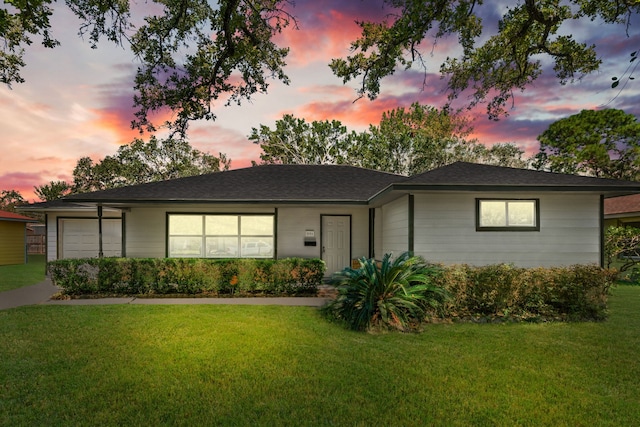 view of front of house with a garage and a lawn