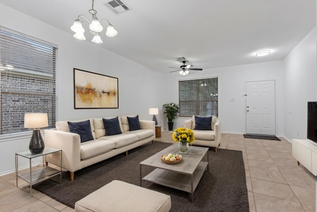 living area with ceiling fan with notable chandelier, light tile patterned flooring, visible vents, and baseboards