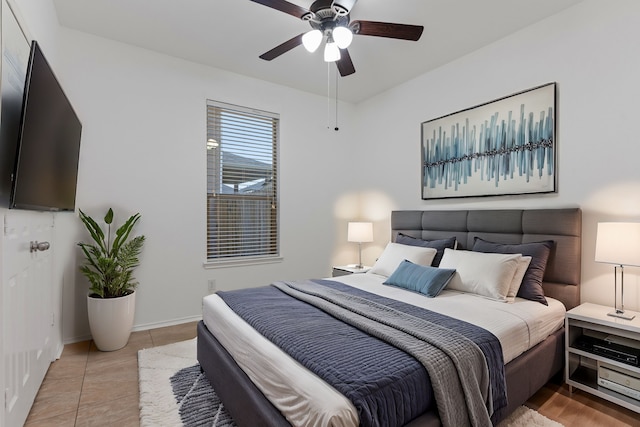 tiled bedroom featuring a ceiling fan and baseboards