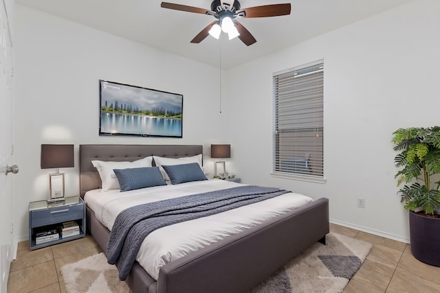 tiled bedroom featuring a ceiling fan and baseboards