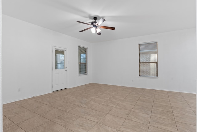 empty room featuring a ceiling fan and baseboards