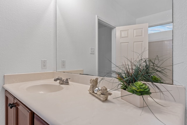 bathroom with a textured wall and vanity