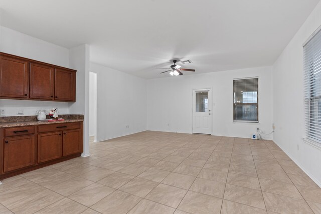 unfurnished living room featuring a ceiling fan and light tile patterned flooring