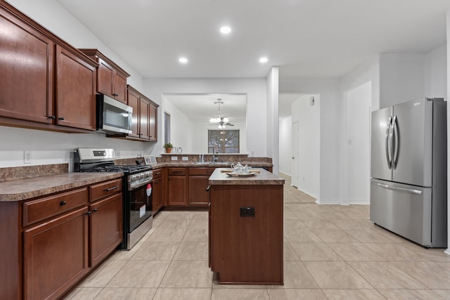 kitchen with a center island, light tile patterned floors, appliances with stainless steel finishes, a sink, and a chandelier