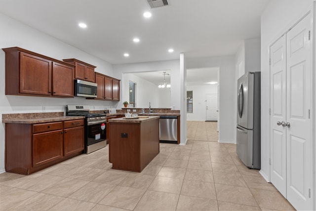 kitchen featuring recessed lighting, a kitchen island, stainless steel appliances, a sink, and light tile patterned flooring