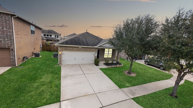 view of front facade featuring brick siding, a front yard, fence, a garage, and driveway