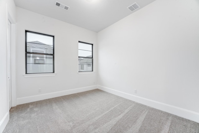 carpeted spare room with baseboards and visible vents