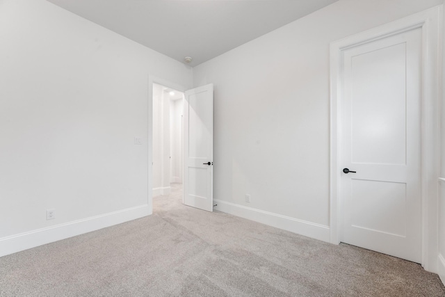 carpeted spare room with baseboards