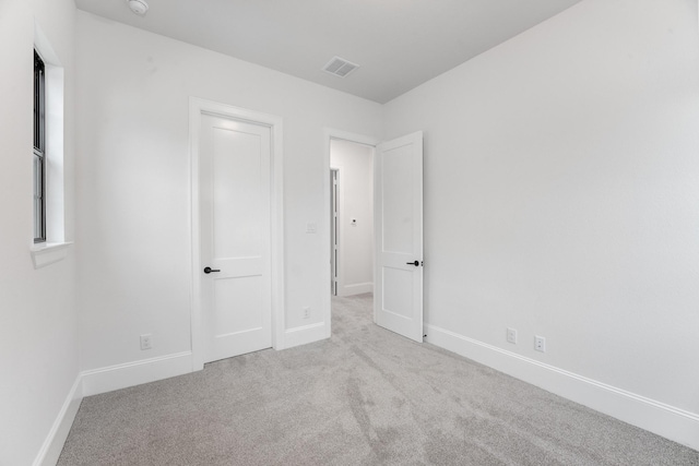 unfurnished bedroom featuring carpet, visible vents, and baseboards