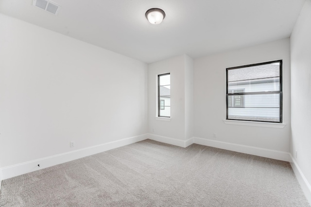 carpeted empty room with visible vents and baseboards