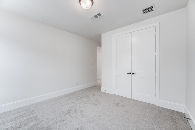 unfurnished bedroom with a closet, baseboards, visible vents, and carpet flooring