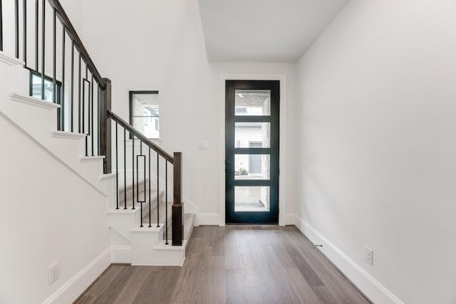 entrance foyer featuring stairway, wood finished floors, and baseboards