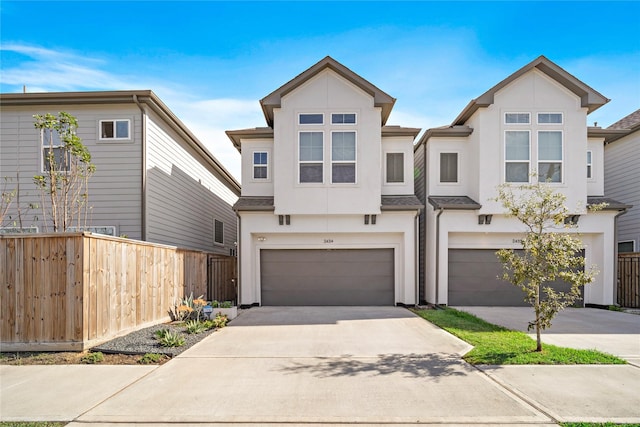 view of property featuring driveway, fence, and stucco siding