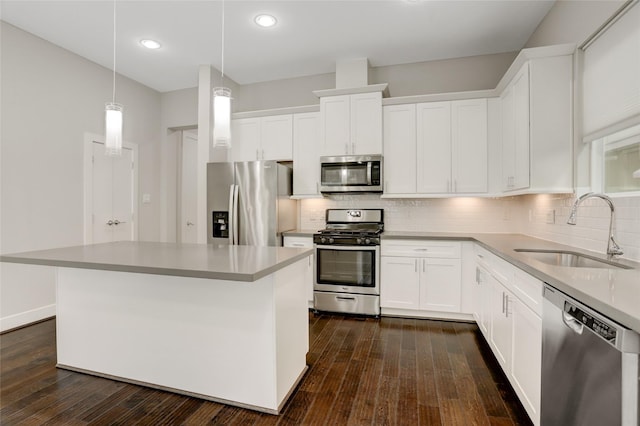 kitchen featuring stainless steel appliances, a sink, backsplash, and dark wood-style floors